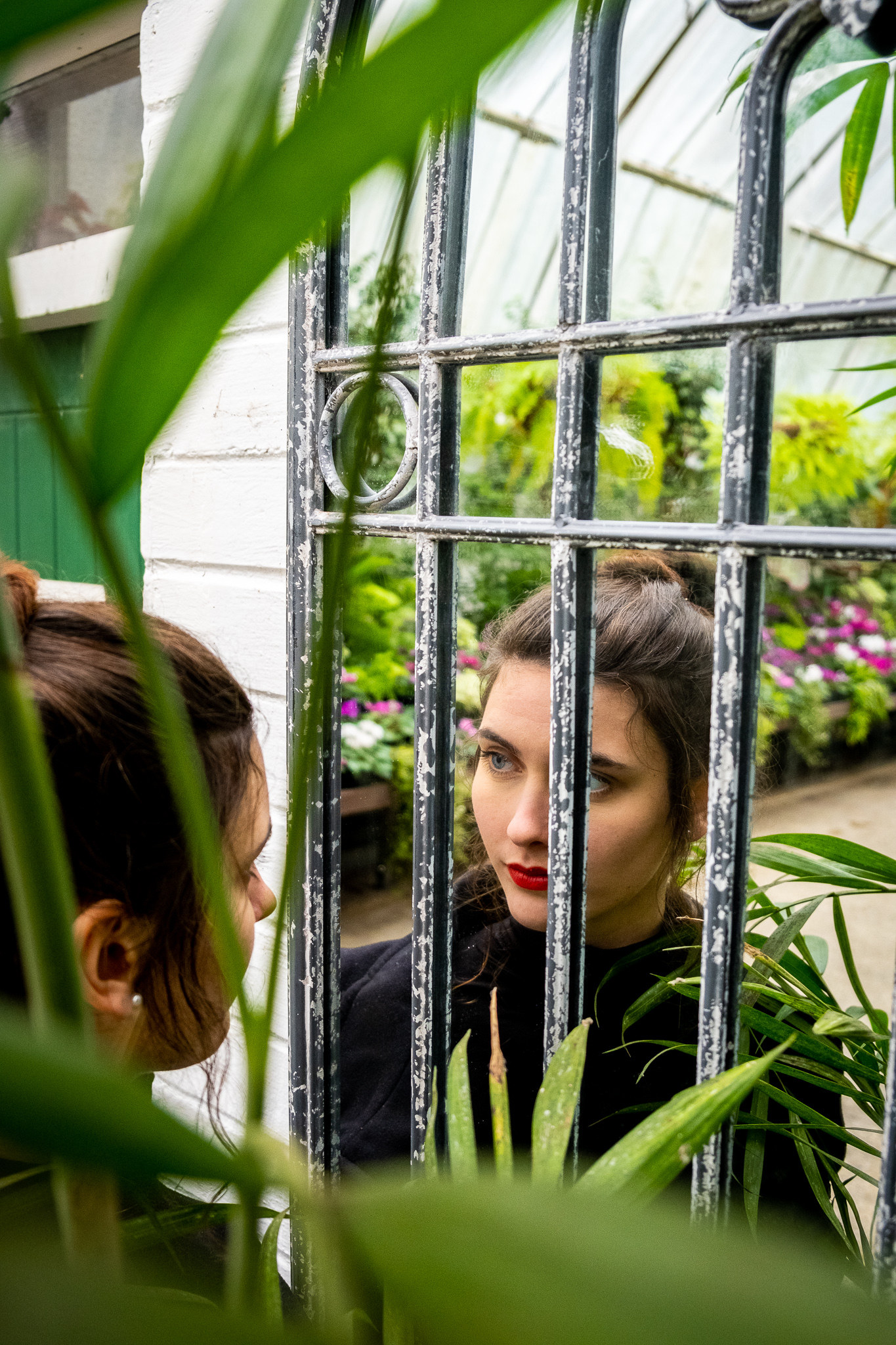 picture of a women in green house looking into a mirror